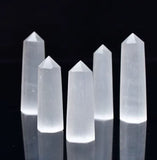 Five polished hexagonal crystal obelisks standing on a reflective black background.
