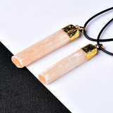 Two Orange necklaces with gold-colored caps on a black surface.