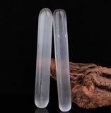 Two smooth polished massage rods standing next to each other.