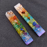 Two copper wire wrapped rainbow colored crystal wands with tumbled chakra stones on a textured dark background.