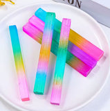 A collection of rainbow sticks displaying various iridescent colors placed on a white plate.