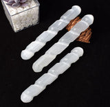 Three spiral wands arranged horizontally on a dark surface.