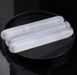 Polished white massage sticks for acupressure with rounded edges.
